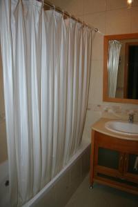 a bathroom with a shower curtain and a sink at Condominio Encosta Da Orada by Garvetur in Albufeira