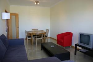 a living room with a couch and a red chair at Condominio Encosta Da Orada by Garvetur in Albufeira