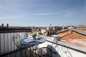 un tavolo e sedie su un balcone con vista di RomeAsYouLike - Babuino Sweet Loft a Roma
