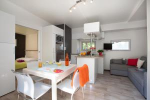 a kitchen and living room with a table and chairs at Mobil home Domaine de Soulac in Soulac-sur-Mer