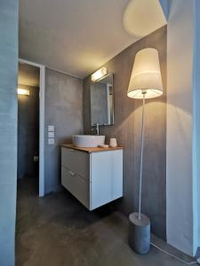 a bathroom with a sink and a floor lamp at The Elephant Beach House in Kimolos