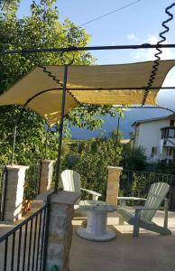 a table and two chairs under an umbrella at Majellame in Caramanico Terme