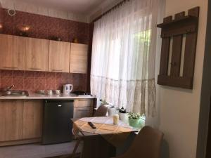 małą kuchnię ze stołem i oknem w obiekcie Dom Wczasowy Aleksander w mieście Puck