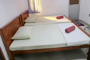 two twin beds in a room with two red pillows at Willwin Park in Anuradhapura