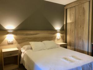 a bedroom with a large white bed with two tables at Pension Antonio in Louro