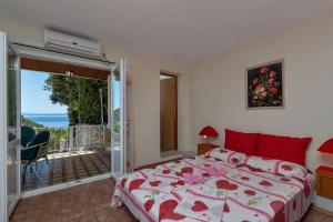 een slaapkamer met een bed en een balkon bij Vila Milena in Krvavica