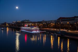 een grote boot is aangemeerd in een rivier 's nachts bij Botel Albatros in Praag