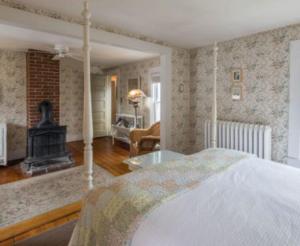 ein Schlafzimmer mit einem Bett und einem Kamin in der Unterkunft Snug Cottage in Provincetown + 70 Fotos