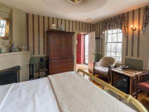 a bedroom with a bed and a living room with a fireplace at Snug Cottage in Provincetown