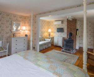 
a living room with a bed and a fireplace at Snug Cottage in Provincetown
