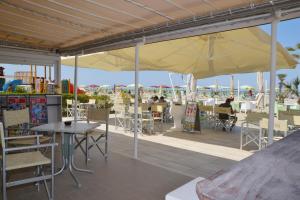 a patio with tables and chairs and umbrellas at Hotel Rossella in Rimini