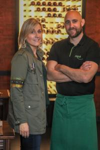 a woman standing next to a man with his arms crossed at Hôtel Argia in Hasparren