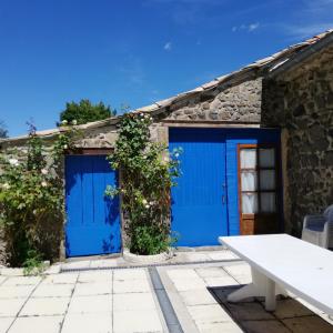 a pair of blue garage doors on a stone building at les écureuils in Saint-Priest