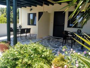 a patio with a table and chairs and some plants at Dasea Houses in Ormos Panagias