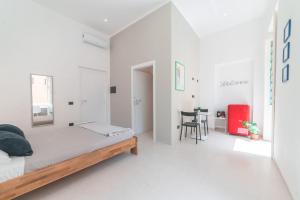 um quarto branco com uma cama e uma mesa em Linee Moderne Apt - Wifi - AC em Cagliari