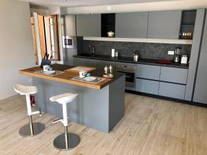 a kitchen with a counter and stools in it at Casa Elisabetta, affacciata sul golfo in Salò