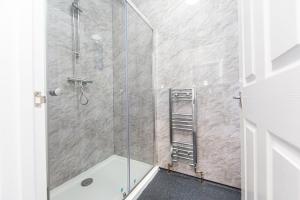 uma casa de banho com um chuveiro e uma porta de vidro em The Glantaff Inn Bunkhouse em Treharris