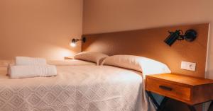 Un dormitorio con una cama grande y una mesa de madera. en Pensión A Marronda, en Baleira
