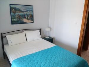 a bedroom with a bed with a blue and white blanket at Dasea Houses in Ormos Panagias