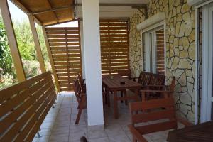 a porch with a wooden table and chairs on it at Pirovac - most beautiful beaches in Dalmatia in Pirovac