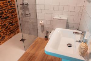 un baño con lavabo y ducha en Pensión A Marronda, en Baleira