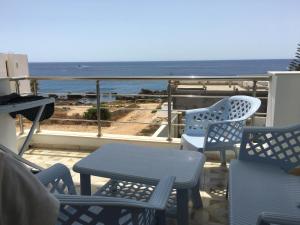 a balcony with chairs and a table and a view of the ocean at Arabesque Style - 2 appartements in Kelibia