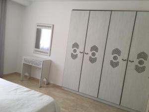 a bedroom with two closets with a bed and a mirror at Arabesque Style - 2 appartements in Kelibia