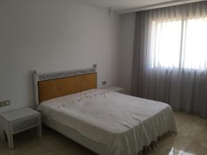a bedroom with a large bed and a window at Arabesque Style - 2 appartements in Kelibia