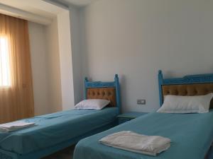 two beds sitting next to each other in a room at Arabesque Style - 2 appartements in Kelibia