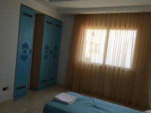 a bedroom with a bed and a window at Arabesque Style - 2 appartements in Kelibia