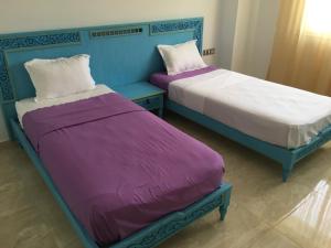 two beds sitting next to each other in a room at Arabesque Style - 2 appartements in Kelibia