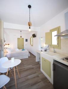 a room with a bed and a kitchen with a table at Diasino Apartments and Car Rental in Katapola
