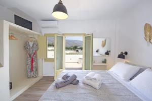 a bedroom with a bed with two towels on it at Diasino Apartments and Car Rental in Katapola