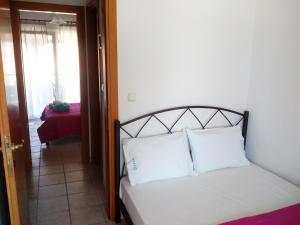 a bedroom with a bed with white pillows on it at Dasea Houses in Ormos Panagias