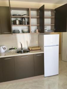 Una cocina con un refrigerador blanco y un fregadero. en Vase Apartments, en Ravda