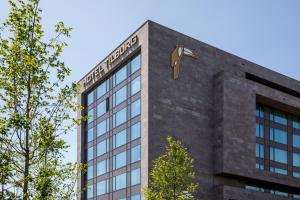 a building with a clock on the top of it at Van der Valk Hotel Tilburg in Tilburg