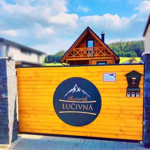 a yellow fence with a mountain lugka sign on it at Rezortík Lučivná pre rodiny s deťmi, 300m od vleku, Vysoké Tatry in Lučivná