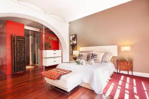 um quarto com uma grande cama branca e uma cadeira em BEACH LOFT TERRACE BCN em Barcelona