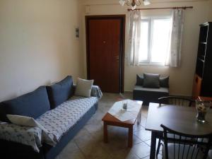 a living room with a blue couch and a table at Dasea Houses in Ormos Panagias