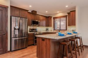 a kitchen with wooden cabinets and a stainless steel refrigerator at Mountainside 4 in Mammoth Lakes