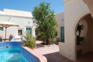 a house with a swimming pool and a building at Hotel Dar Dhiafa in Houmt Souk
