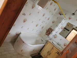 baño con bañera y pared de azulejos en Hotel Rosim, en Latacunga