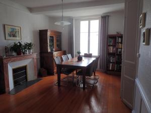 a dining room with a table and chairs and a fireplace at La Miramboise, chambres et table d hôtes in Mirambeau