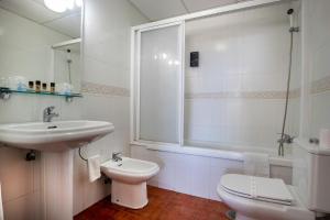 
a bathroom with a toilet, sink, and shower at Hotel y Bungalows Balcón de Competa in Cómpeta
