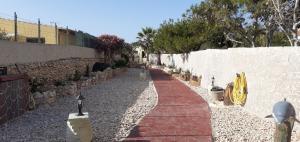a red brick walkway next to a stone wall at La Casa Dei Delfini in Lampedusa