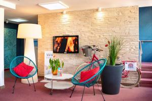 a room with two chairs and a table and a fireplace at centra Hotel in Schwedt
