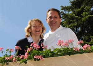 mężczyzna i kobieta stojący przed kwiatami w obiekcie Hostel Chalet Stöckli mit Etagendusche w mieście Wilderswil