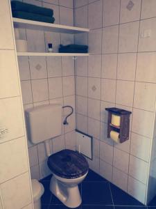 a small bathroom with a toilet with a black seat at Baumgartnerhof Arriach - Urlaub am Bauernhof in Arriach