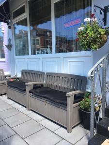 two benches sitting in front of a store at Glenheath Hotel in Blackpool