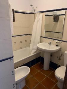 Un baño con lavabo, bañera e inodoro. en Masia de San Juan - castillo con piscina en plena Sierra Calderona, en Segorbe